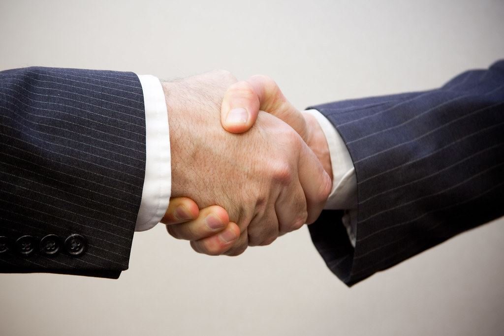 Apretón de manos entre dos profesionales cerrando un acuerdo
